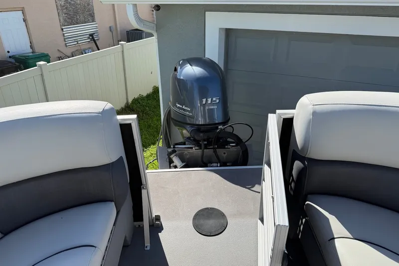 Slide: The Image of 2020 Sylvan Mirage 822 LZ boat with Yamaha 115 engine, parked near a garage. - 17