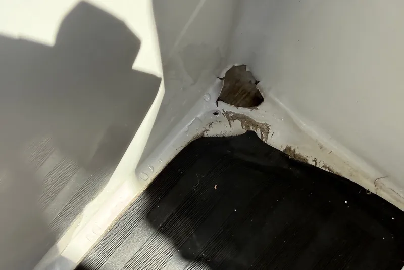Slide: The Image of Damaged interior corner of 2020 Sylvan Mirage 822 LZ boat, showing hole and wear. - 14