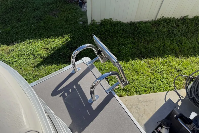 Slide: The Image of 2020 Sylvan Mirage 822 LZ boat ladder on deck, surrounded by green grass. - 19