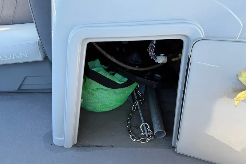 Slide: The Image of Storage compartment of a 2020 Sylvan Mirage 822 LZ boat with chain and green bag. - 23