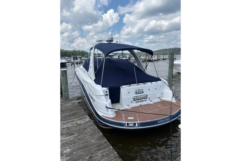 Slide: The Image of 2005 Four Winns 348 Vista boat docked at a marina under a cloudy sky. - 5