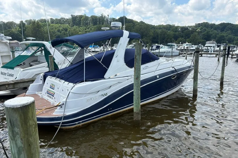 Slide: The Image of 2005 Four Winns 348 Vista boat docked at a marina, featuring a blue canopy. - 2