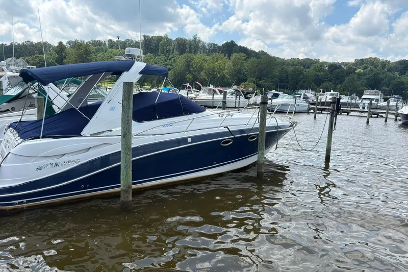 Slide: The Image of 2005 Four Winns 348 Vista boat docked at a marina under a cloudy sky. - 3