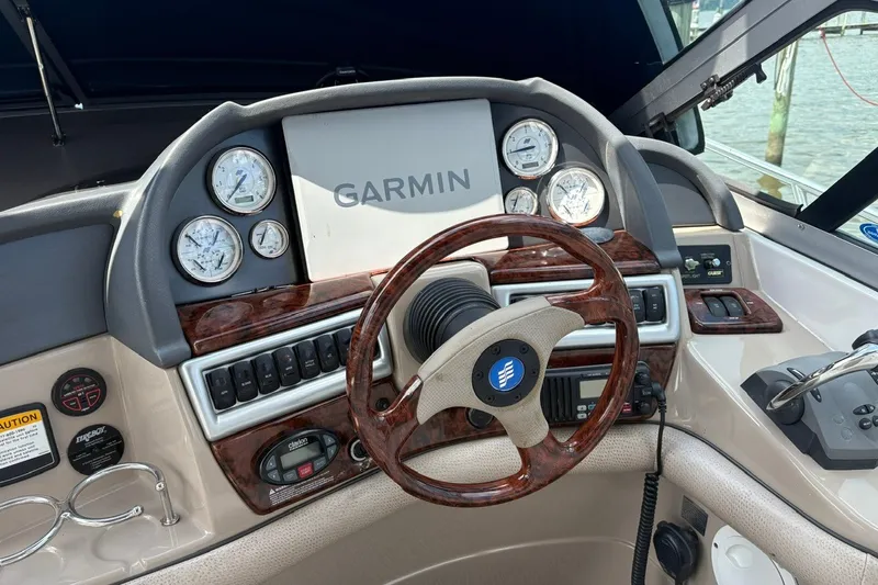 Slide: The Image of 2005 Four Winns 348 Vista boat dashboard with Garmin navigation and wood-trimmed steering wheel. - 10