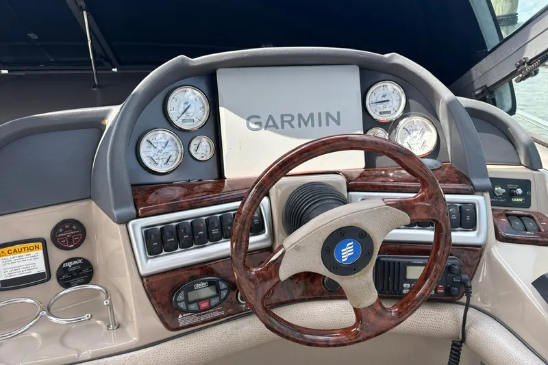 Slide: The Image of 2005 Four Winns 348 Vista boat dashboard with Garmin navigation and wood-trimmed steering wheel. - 9