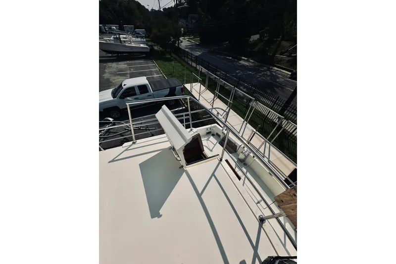 Slide: The Image of 1996 Sabreline 36 Sedan boat deck with railing, parked near a white truck. - 81
