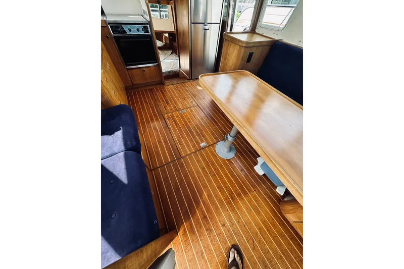Slide: The Image of Interior of 1996 Sabreline 36 Sedan with wooden flooring and dining area. - 79
