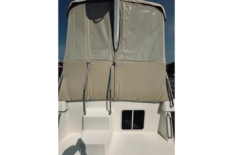 Slide: The Image of 1996 Sabreline 36 Sedan boat with beige canopy and railing, viewed from the stern. - 82