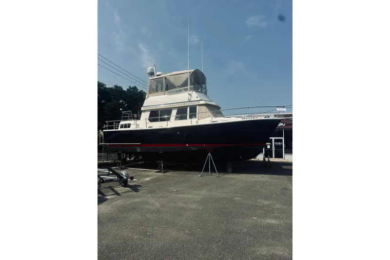 The Image of 1996 Sabreline 36 Sedan boat on dry dock under clear sky. - 0