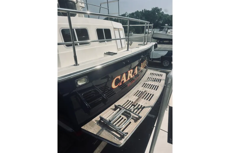 Slide: The Image of 1996 Sabreline 36 Sedan boat with wooden deck and railing, docked at marina. - 8