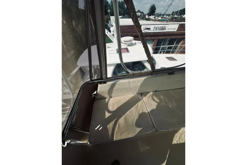 Slide: The Image of 1996 Sabreline 36 Sedan interior view with beige seating and marina background. - 85