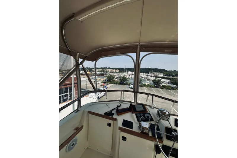 Slide: The Image of Interior view of 1996 Sabreline 36 Sedan yacht helm with marina background. - 101