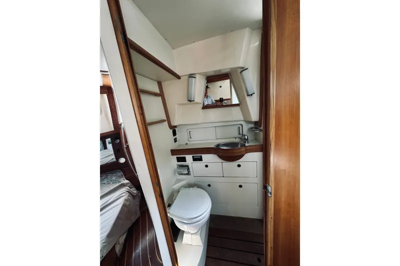 Slide: The Image of 1996 Sabreline 36 Sedan bathroom with sink, mirror, and wooden accents. - 53