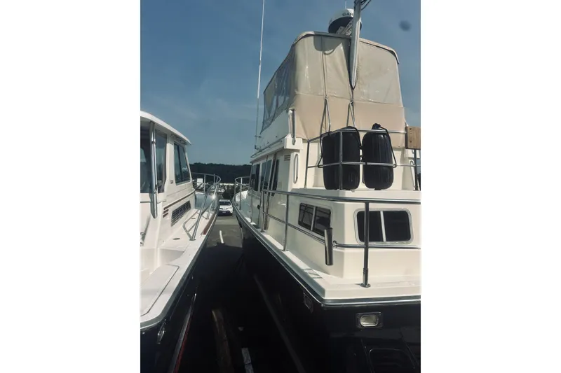 Slide: The Image of 1996 Sabreline 36 Sedan yacht docked, featuring a beige canopy and sleek design. - 12