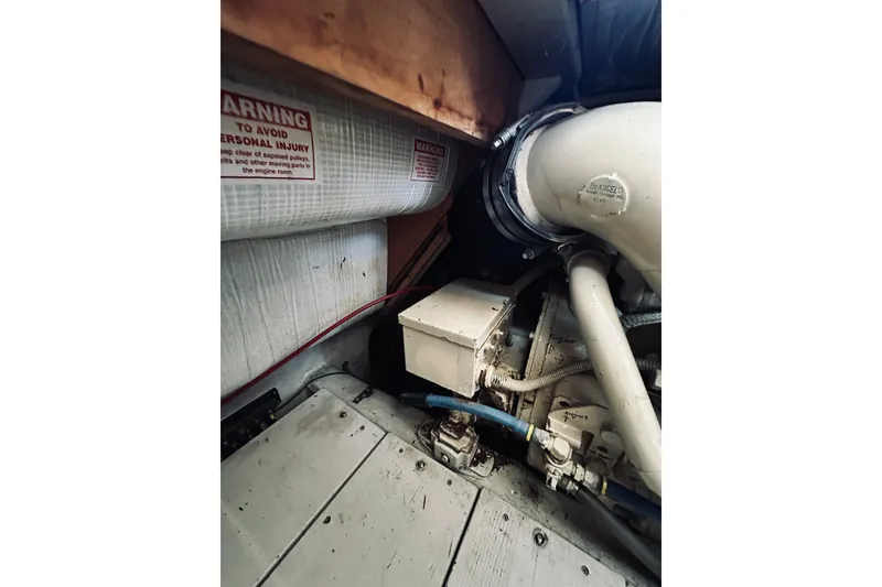 Slide: The Image of Engine room of a 1996 Sabreline 36 Sedan boat, showing mechanical components and warning labels. - 78