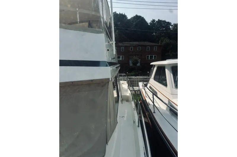 Slide: The Image of 1996 Sabreline 36 Sedan yacht docked, side view with railing and neighboring boat. - 18