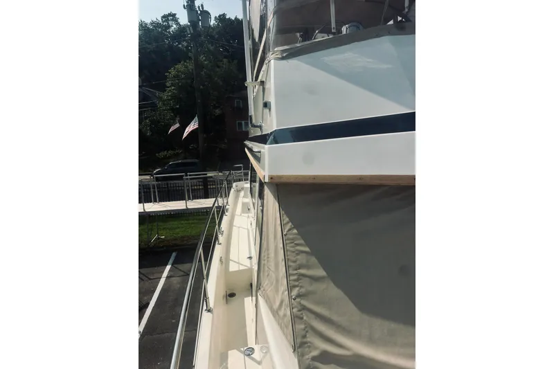 Slide: The Image of 1996 Sabreline 36 Sedan boat side view with dock and American flags. - 19