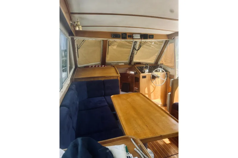 Slide: The Image of Interior of 1996 Sabreline 36 Sedan boat with wooden table and blue seating. - 21