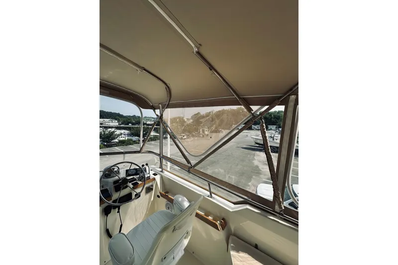 Slide: The Image of 1996 Sabreline 36 Sedan boat interior with steering wheel and canopy view. - 99