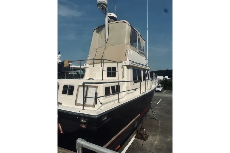 Slide: The Image of 1996 Sabreline 36 Sedan yacht with beige canopy, docked under clear blue sky. - 10