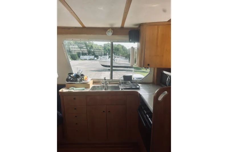 Slide: The Image of 1996 Sabreline 36 Sedan kitchen interior with wooden cabinets and large window view. - 23
