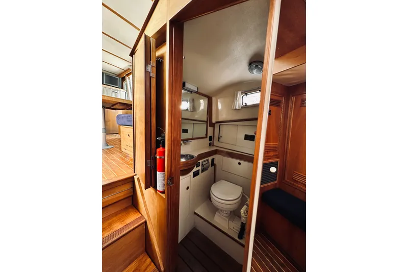 Slide: The Image of 1996 Sabreline 36 Sedan boat interior with wooden cabinetry and compact bathroom. - 42