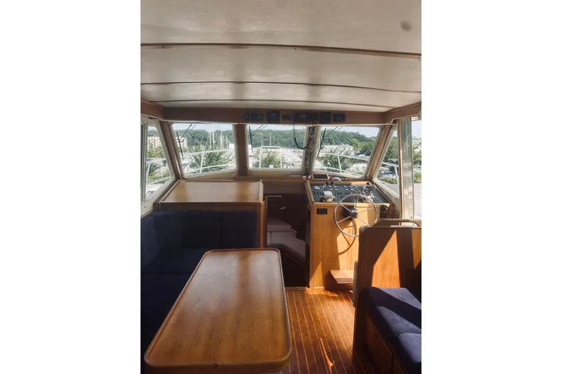 Slide: The Image of Interior of a 1996 Sabreline 36 Sedan boat with wooden furnishings and steering wheel. - 36