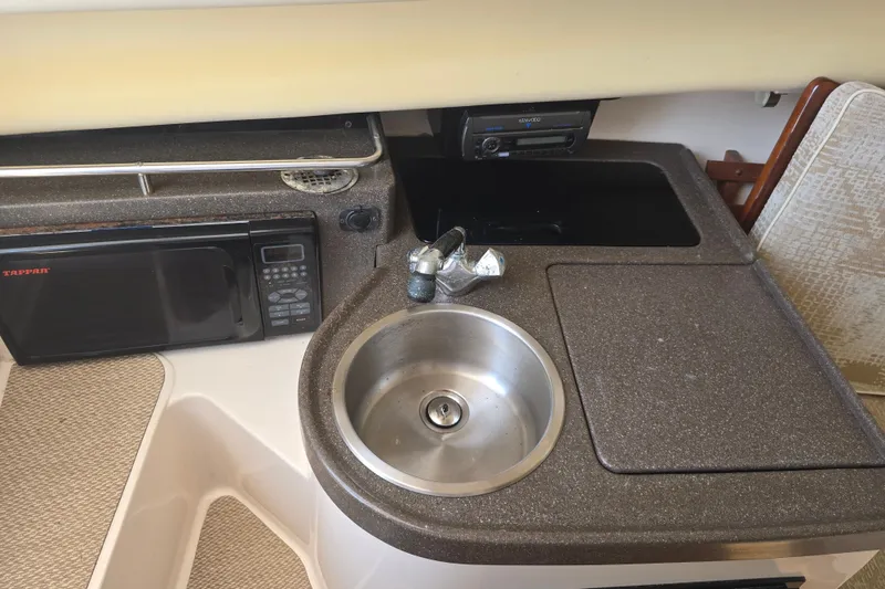 Slide: The Image of 2008 Grady White 282 Sailfish boat interior with sink, microwave, and stereo system. - 25