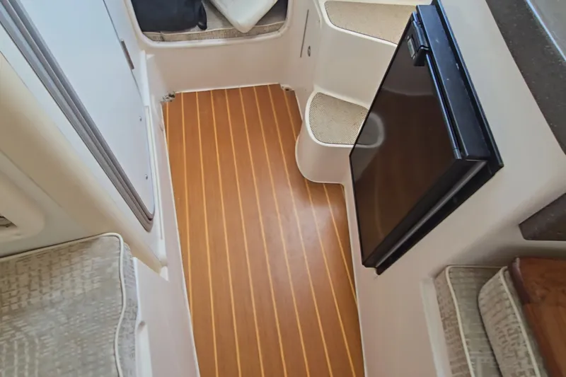 Slide: The Image of Interior of 2008 Grady White 282 Sailfish boat with wood flooring and compact fridge. - 24