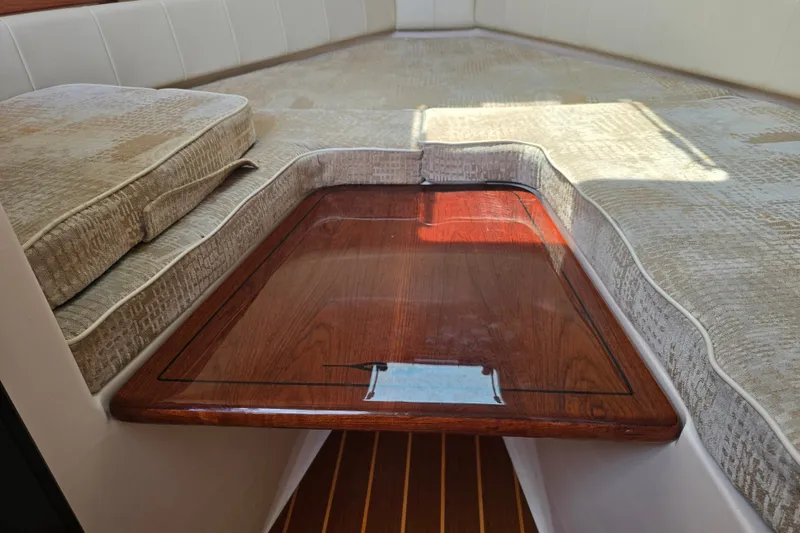 Slide: The Image of Interior of 2008 Grady White 282 Sailfish boat with cushioned seating and wooden table. - 28