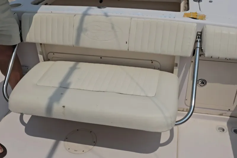 Slide: The Image of Foldable seat on a 2008 Grady White 282 Sailfish boat, featuring white upholstery and metal supports. - 23