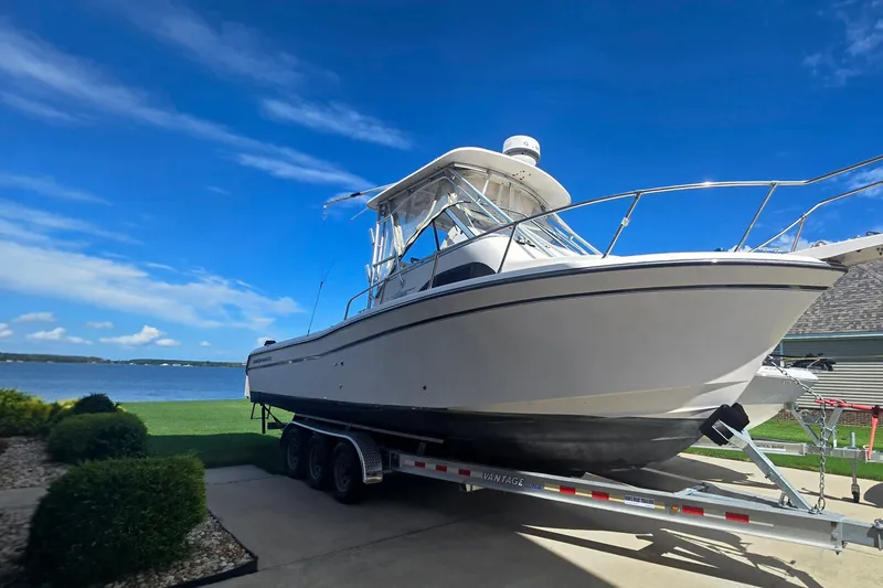 The Image of 2008 Grady White 282 Sailfish boat on trailer by a lake under blue sky. - 1