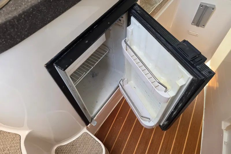 Slide: The Image of Open refrigerator on 2008 Grady White 282 Sailfish boat, showcasing interior storage space. - 27