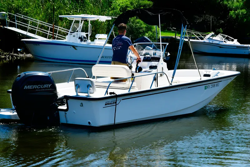 The Image of 2019 Boston Whaler 190 Montauk boat with Mercury engine on a calm waterway. - 1