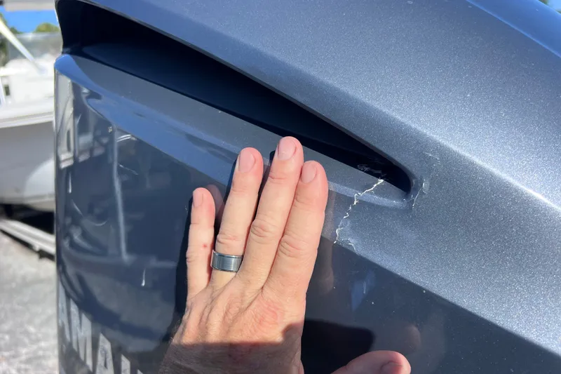 Slide: The Image of Hand inspecting crack on 2012 Parker 2320 SL Sport Cabin boat exterior. - 39
