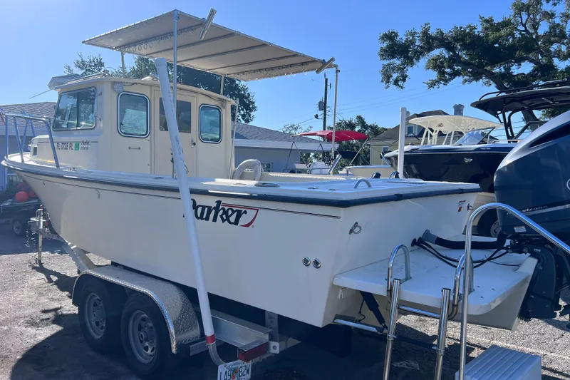 Slide: The Image of 2012 Parker 2320 SL Sport Cabin boat on trailer, outdoor setting. - 4