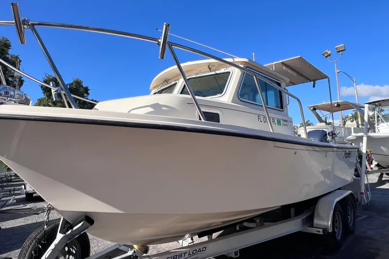 Slide: The Image of 2012 Parker 2320 SL Sport Cabin boat on trailer under clear blue sky. - 1