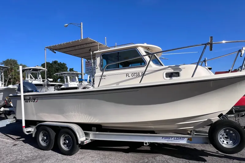 The Image of 2012 Parker 2320 SL Sport Cabin boat on trailer under clear blue sky. - 0