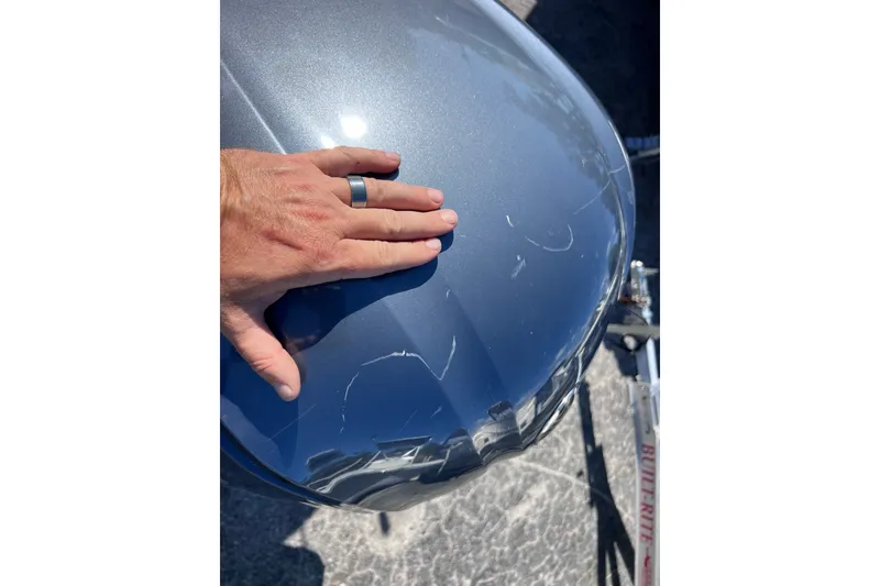 Slide: The Image of Hand inspecting scratches on 2012 Parker 2320 SL Sport Cabin boat hull. - 40