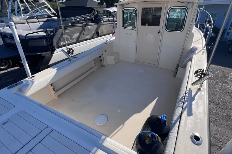 Slide: The Image of 2012 Parker 2320 SL Sport Cabin boat deck, spacious and clean, with visible cabin doors. - 10