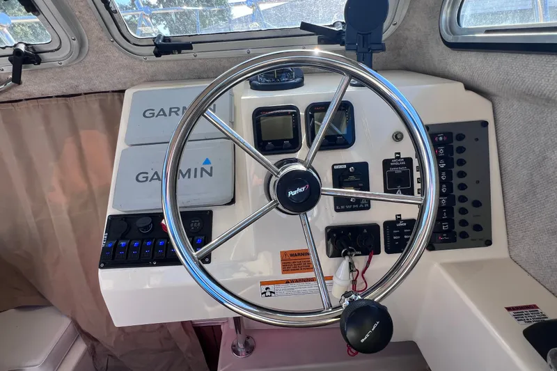 Slide: The Image of Steering wheel and controls of a 2012 Parker 2320 SL Sport Cabin boat. - 29