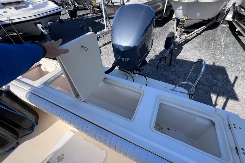 Slide: The Image of 2012 Parker 2320 SL Sport Cabin boat with open storage compartments and outboard motor. - 13