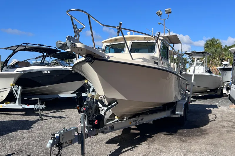 Slide: The Image of 2012 Parker 2320 SL Sport Cabin boat on trailer, surrounded by other boats. - 2