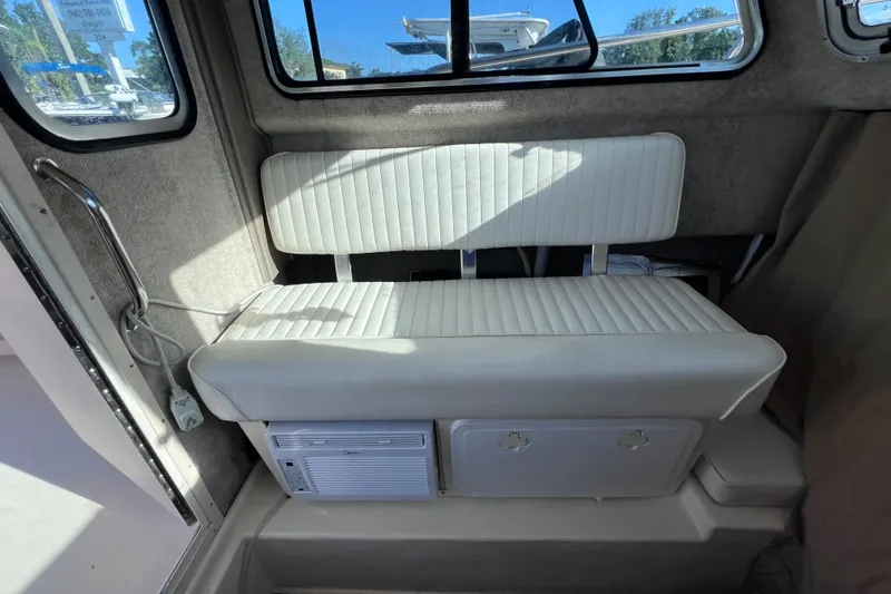 Slide: The Image of Interior of 2012 Parker 2320 SL Sport Cabin with white seating and storage compartment. - 25