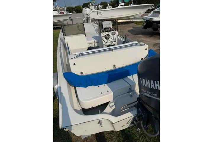 Slide: The Image of 1988 Boston Whaler 150 Super Sport boat with Yamaha outboard motor, parked on grass. - 13