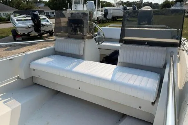 Slide: The Image of 1988 Boston Whaler 150 Super Sport interior with white seating and dual consoles. - 6