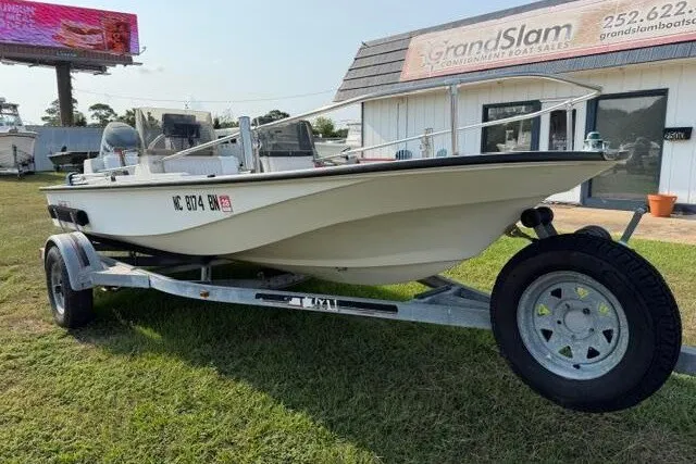 Slide: The Image of 1988 Boston Whaler 150 Super Sport boat on trailer, parked outside dealership. - 2