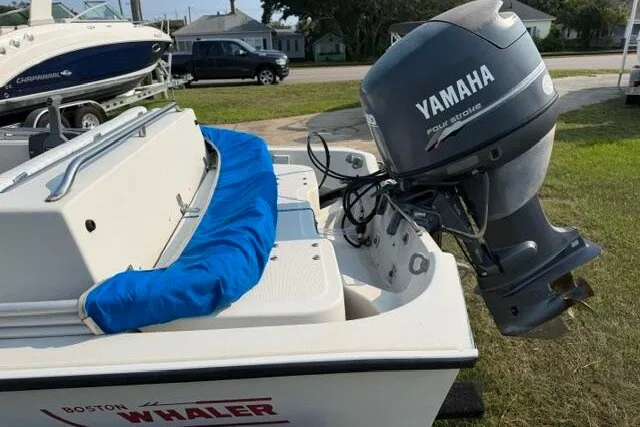 Slide: The Image of 1988 Boston Whaler 150 Super Sport with Yamaha outboard motor, parked on grass. - 9