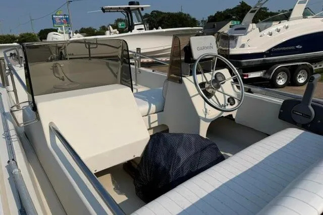 Slide: The Image of 1988 Boston Whaler 150 Super Sport boat interior with steering wheel and seating. - 8