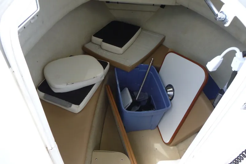 Slide: The Image of Interior of a 2010 Trophy 2152 Walkaround boat with cushions and storage items. - 11